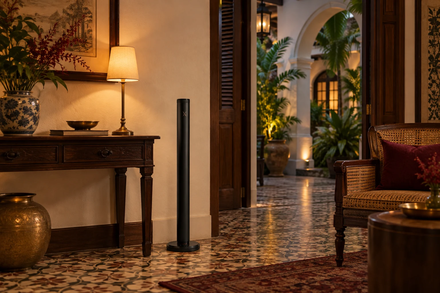 An X AP40 diffuser beside a teak console in a heritage hotel reception with arched garden views and warm lamp light