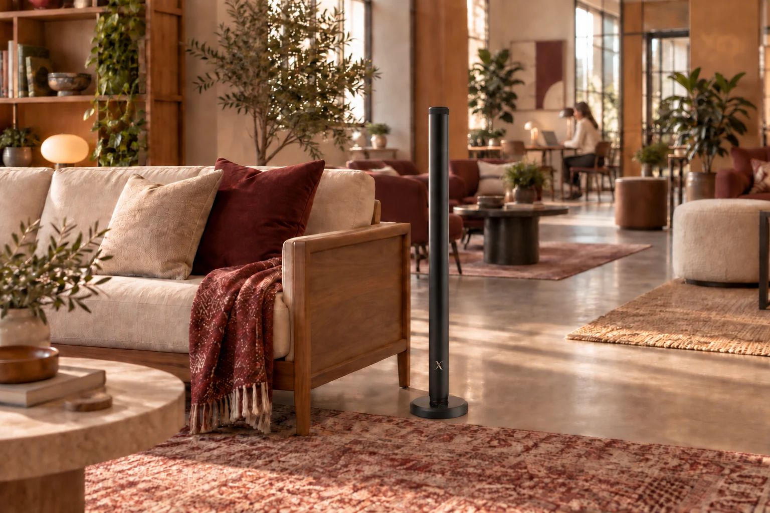 A warm shared-work lounge with connected seating areas and an X AP40 floor diffuser.
