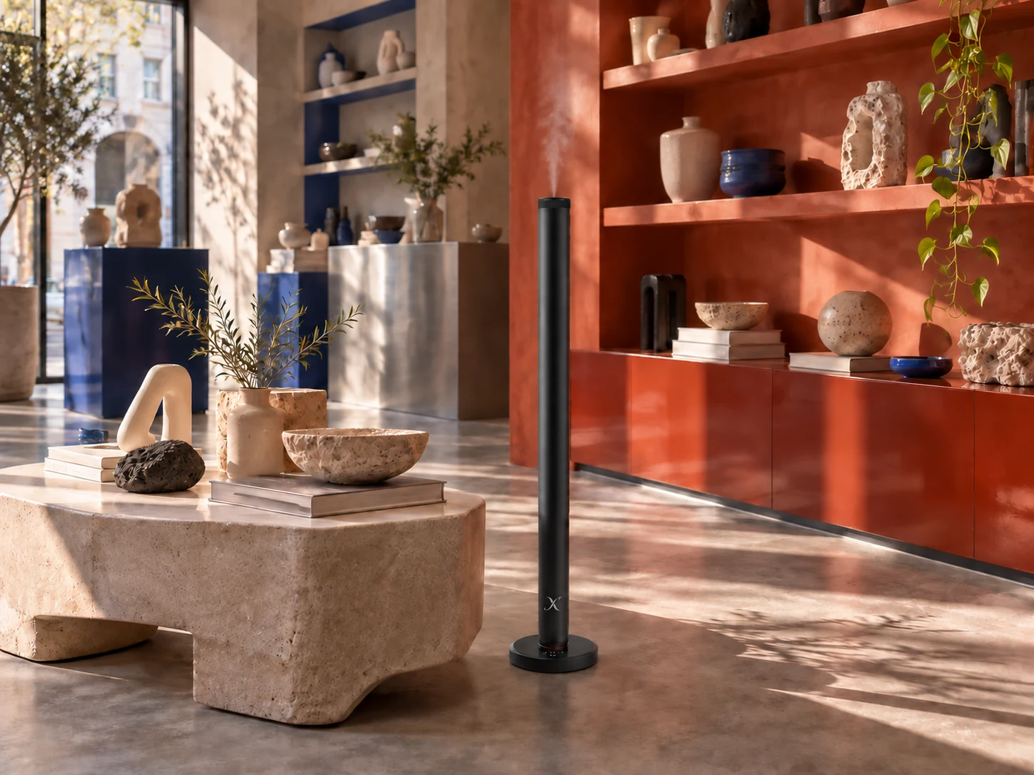 A black X AP40 floor diffuser among terracotta shelves, blue accents and sculptural objects in a contemporary design store