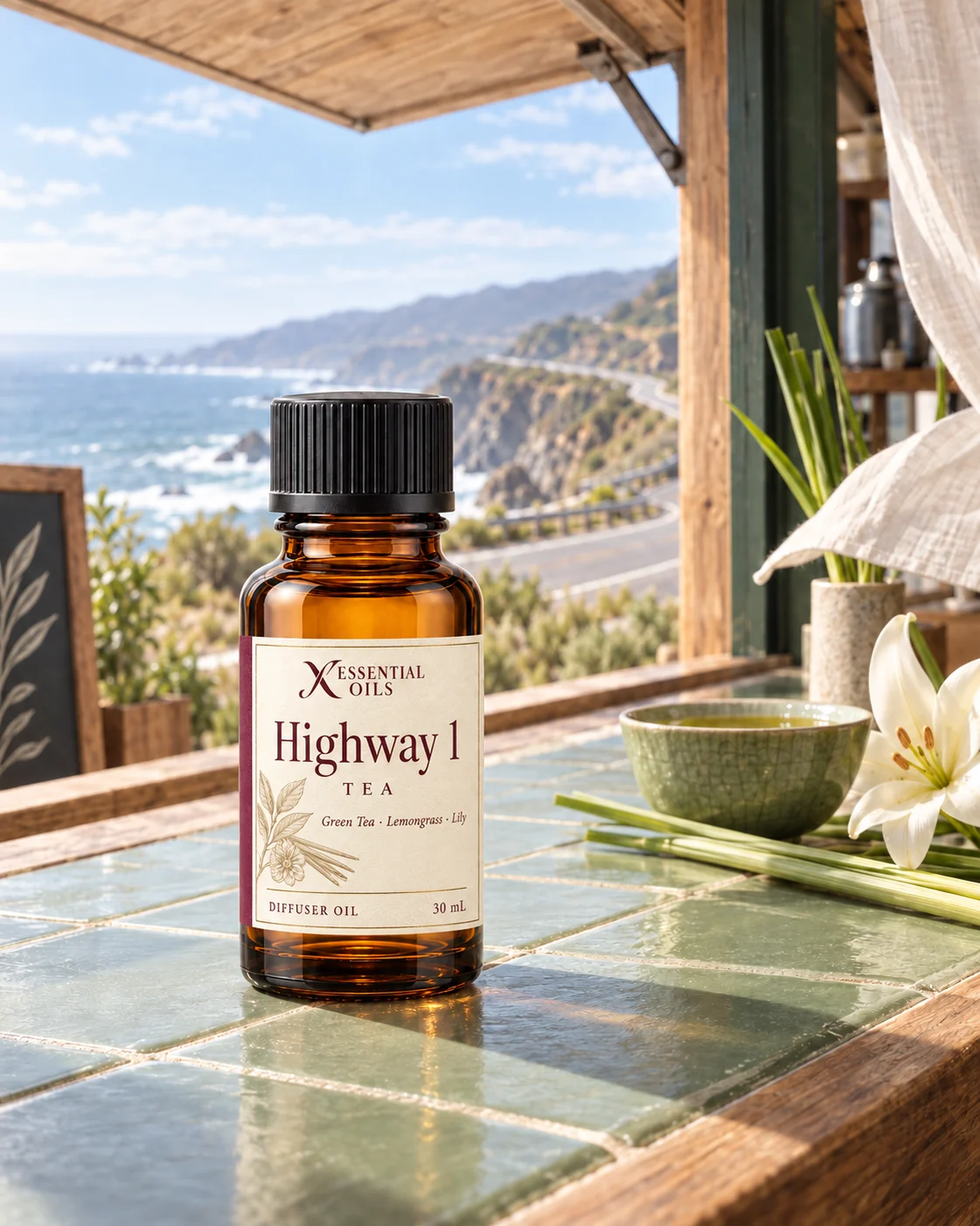 Highway 1 fragrance bottle on a sage-tiled coastal tea cabin counter overlooking a winding ocean road.
